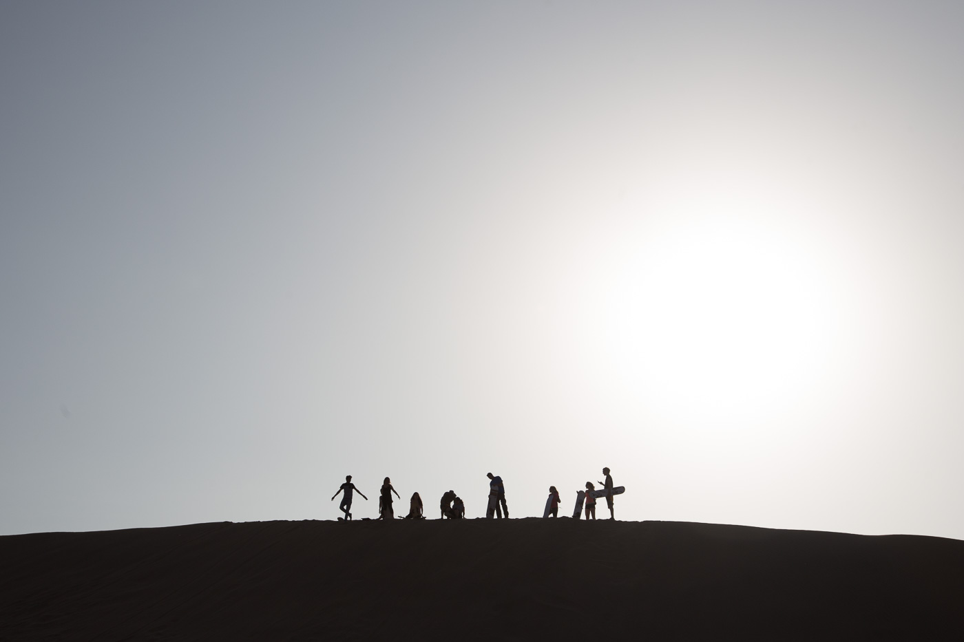 Everyone readies (and does weird poses) before sandboarding the massive dunes of Huacachina.